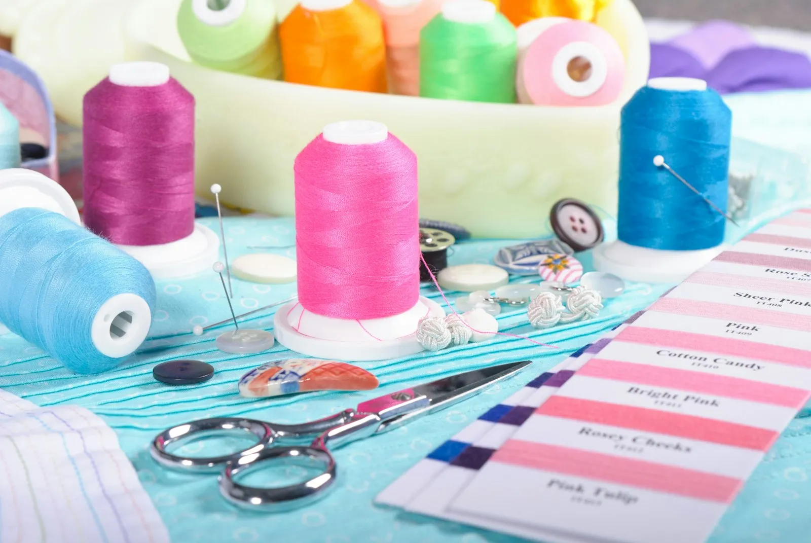 Sewing and quilting tools — thread, scissors and fabric swatches laid out on a table