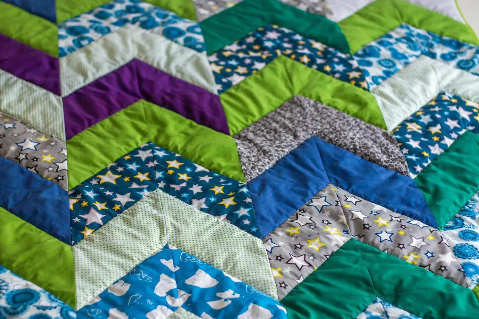A close-up of a colourful patchwork quilt made from repeating blocks